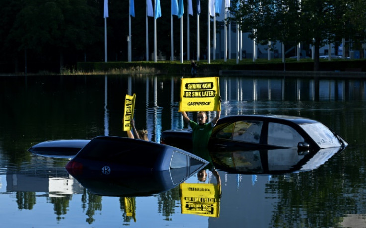 Greenpeace activists submerged three cars in a small lake outside the IAA convention centre