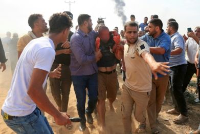 Palestinians lead an apparently captured and injured Israeli man in Khan Yunis in the southern Gaza Strip, on October 7, 2023