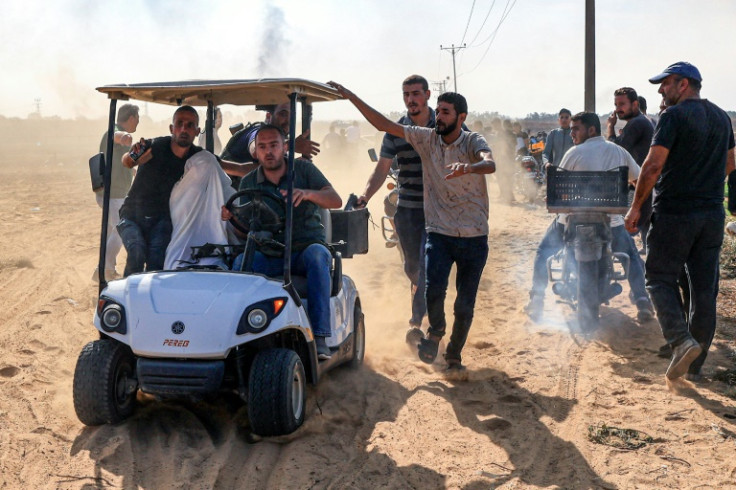Palestinian militants ride a vehicle carrying what is reportedly an Israeli hostage under a white sheet, in Khan Yunis in the southern Gaza Strip, on October 7, 2023