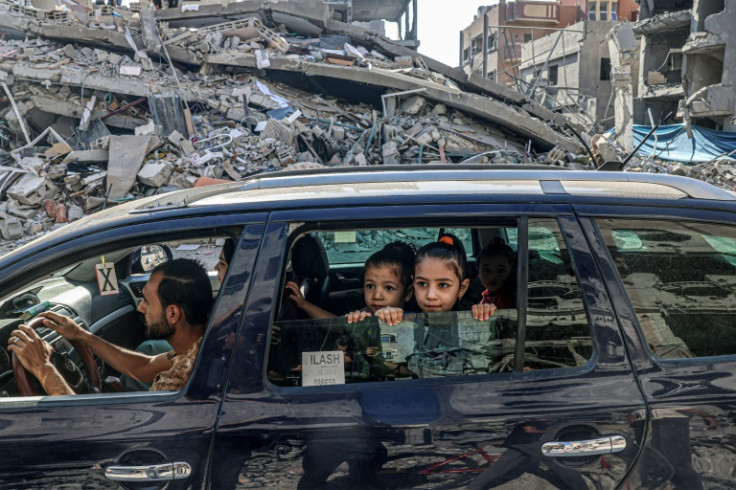 Palestinians drive amid the rubble of buildings destroyed in an Israeli air strike in Rafah, on the southern Gaza Strip