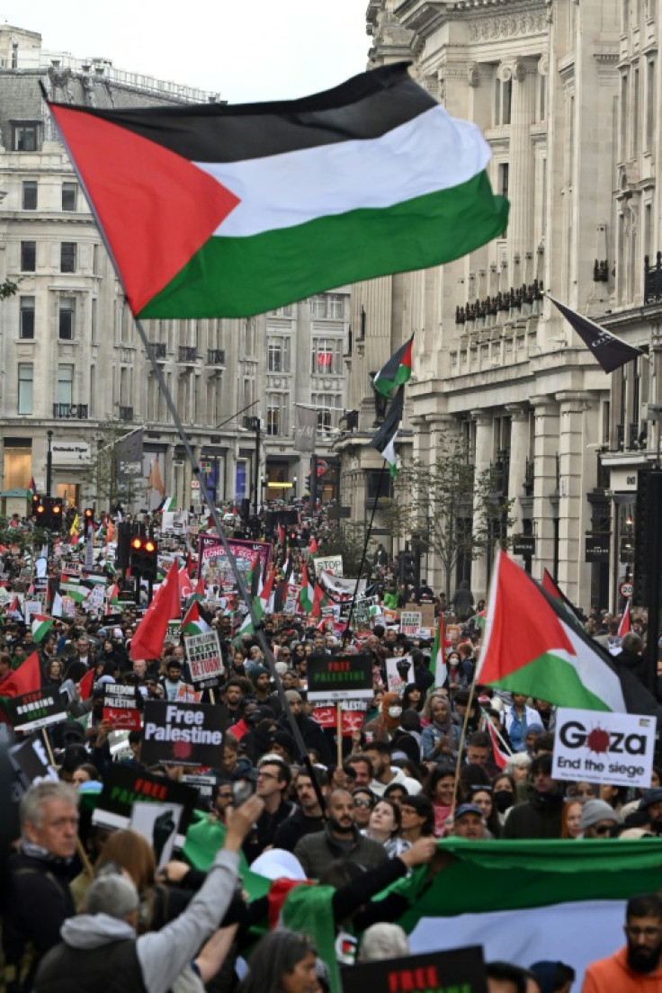 People wave Palestinian flags as at a pro-Palestinian protest in London on October 14, 2023