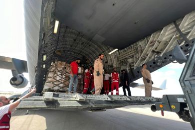 Volunteers from Qatar and Egypt's Red Crescent unload aid destined for the Gaza Strip at Egypt's El Arish airport