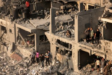 People search for survivors and the bodies of victims through buildings that were destroyed during Israeli bombardment, in Khan Yunis in the southern Gaza Strip on October 25, 2023