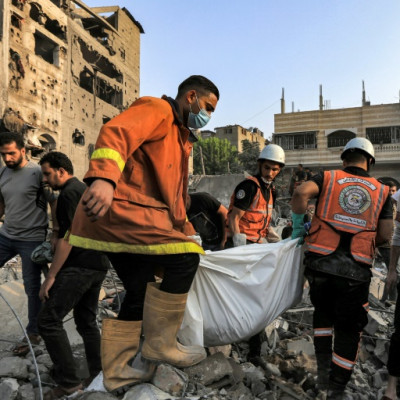 Palestinian civil defence members carry the body of a person killed during Israeli bombardment in Khan Yunis in the southern Gaza Strip on October 25, 2023