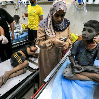A woman waits with two children injured in Israeli bombardment at the trauma ward at Nasser hospital in Khan Yunis in the southern Gaza Strip on October 24, 2023