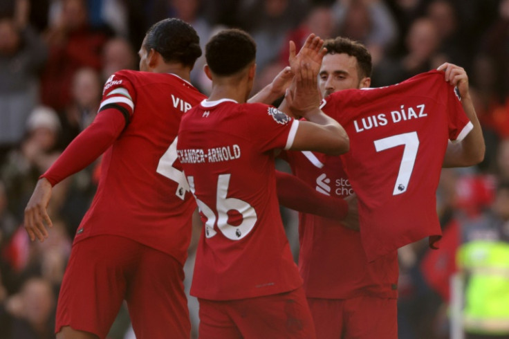 Liverpool forward Diogo Jota shows off a shirt with the name of forward Luis Diaz