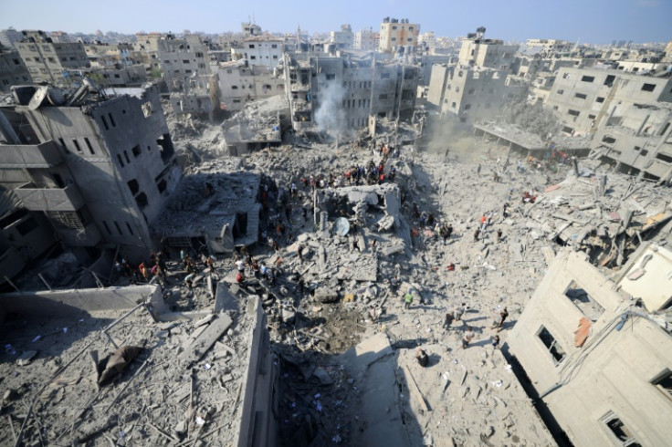 People search for survivors and bodies in the rubble of buildings destroyed in a strike on the Bureij refugee camp in the central Gaza Strip on November 2, 2023
