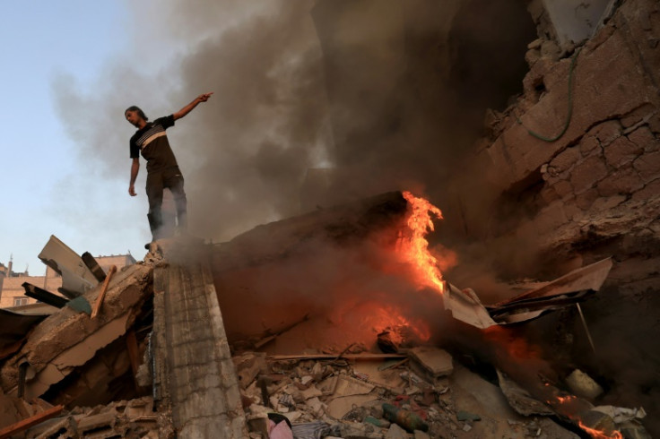 A Palestinian on the rubble of a collapsed building following an Israeli strike on Khan Yunis in south Gaza