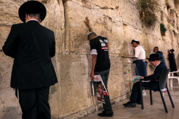A man touches the Western Wall, the holiest site where Jews are allowed to pray, in the Old City of Jerusalem.