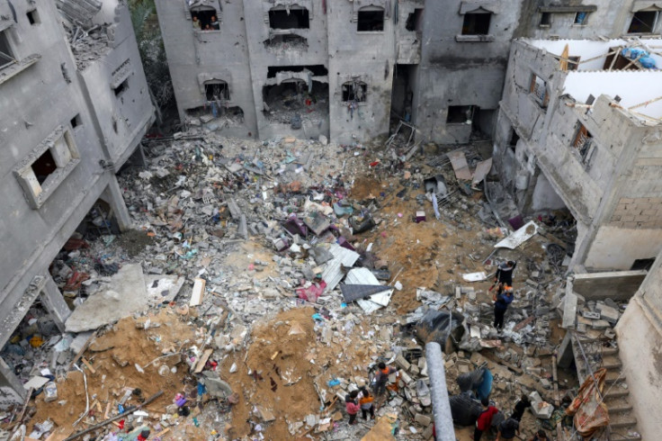 People salvage belongings in the rubble of damaged buildings following strikes in southern Gaza