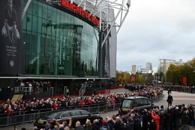 A hearse carrying the coffin of Bobby Charlton is driven past Old Trafford