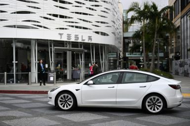 A Tesla electric vehicle drives past the Tesla Inc Santa Monica Place store, in Santa Monica, California