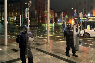 Irish riot police form a cordon in Dublin as people take to the streets following a suspected school stabbing