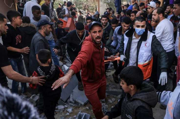 A Palestinian medic and civilians carry an injured man after an Israeli strike on Rafah, in the southern Gaza Strip, ahead of an expected pause in fighting