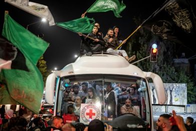 A crowd surrounds a Red Cross bus carrying Palestinian prisoners released from Israeli jails in Ramallah in the occupied West Bank