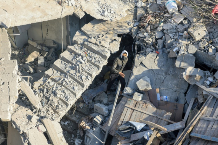 A man stands among the rubble of a building destroyed in bombardment overnight in Rafah in the southern Gaza Strip on December 7, 2023