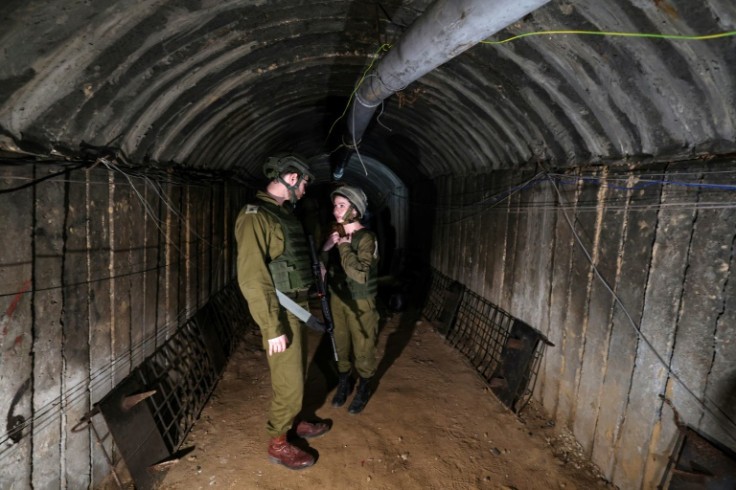 In this picture taken during a media tour organised by the Israeli military on December 15, 2023, soldiers visit a tunnel that Hamas reportedly used to attack Israel through the Erez border crossing on October 7