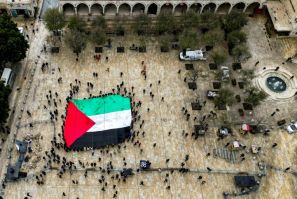 A giant Palestinian flag is unfurled outside the Church of the Nativity in the biblical city of Bethlehem in the occupied West Bank on Christmas Eve