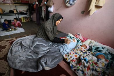 Iman al-Masri, a displaced Palestinian woman in Gaza, feeds one of her quadruplets, the fourth of whom is still being treated in hospital