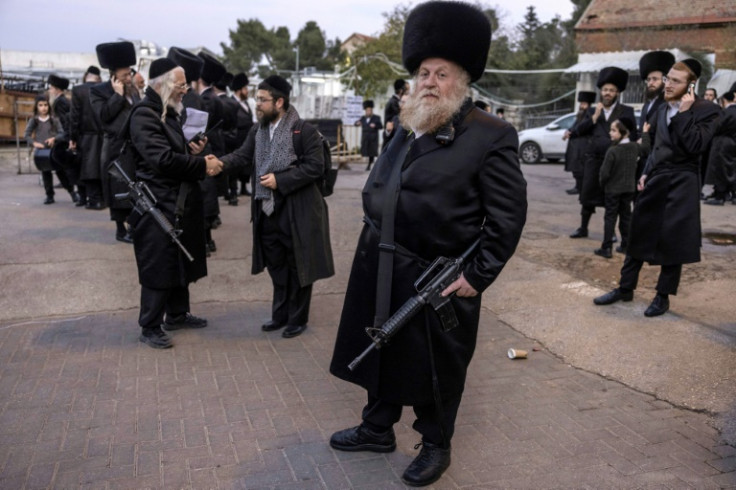 Ultra-orthodox Jewish men armed with M16 rifles stand guard during a wedding event in Jerusalem on December 27, 2023