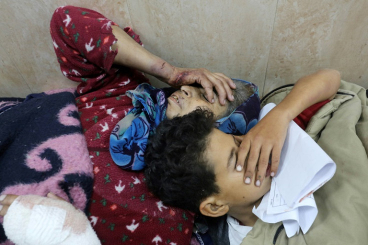 A woman and child injured in an Israeli bombardment lie at a hospital in Gaza on December 30, 2023