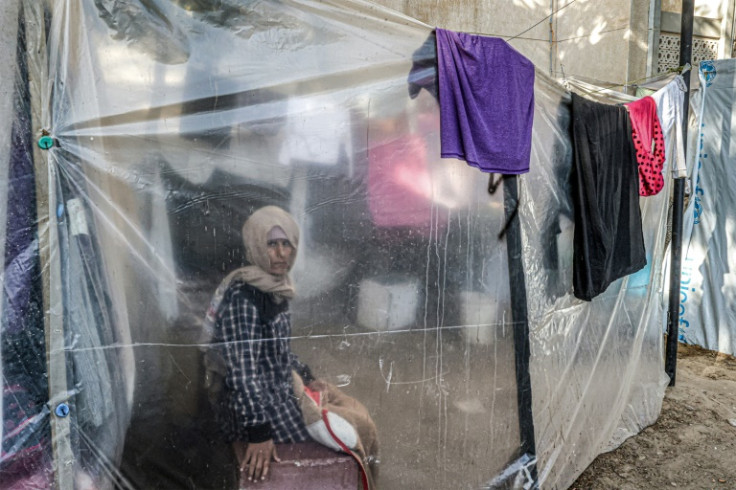 A displaced Palestinian woman sits in a makeshift tent in Khan Yunis in the southern Gaza Strip on December 31, 2023