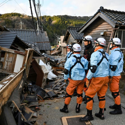 Firefighters inspect collapsed wooden houses in the city of Wajima on Japan's Noto Peninsula, the area hardest hit by the New Year's Day earthquake