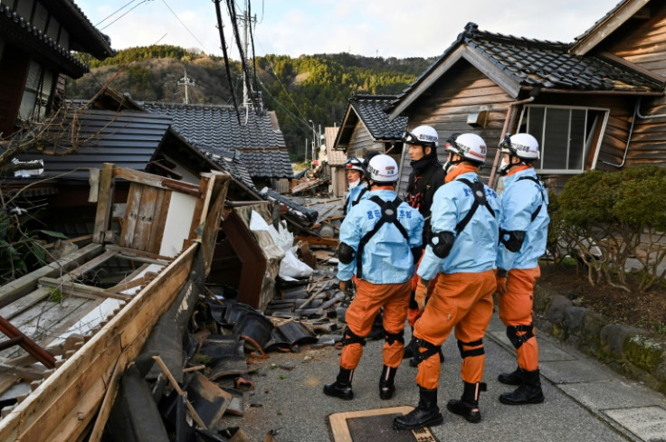 Firefighters inspect collapsed wooden houses in the city of Wajima on Japan's Noto Peninsula, the area hardest hit by the New Year's Day earthquake