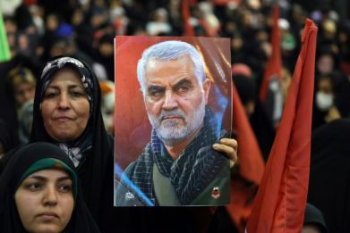 An Iranian woman holds a portrait of slain top Iranian commander Qasem Soleimani during the commemoration ceremony marking the anniversary of his killing in the Iranian capital Tehran on January 3, 2024