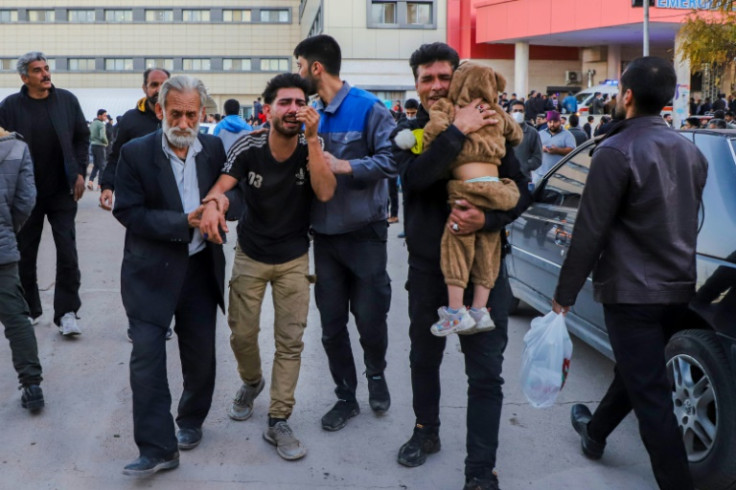 People injured in the explosions are helped outside a hospital in the southern Iranian city of Kerman on January 3, 2024