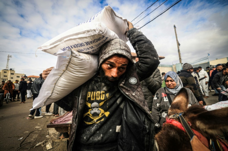 Displaced Palestinians receive food aid at the United Nations Relief and Works Agency for Palestine Refugees