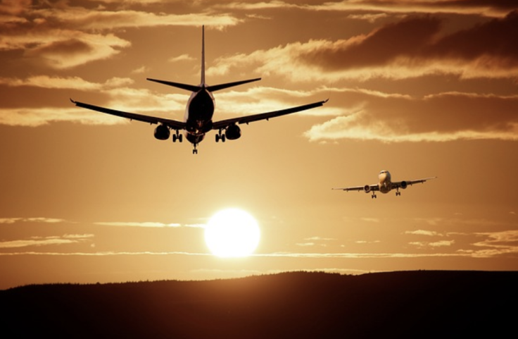 Airplane flying through the sunset