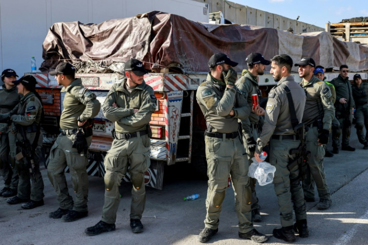 Israeli security forces stand guard by one of the Egyptian trucks bringing in humanitarian aid supplies to the Gaza Strip