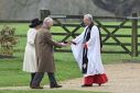 Reverend Paul Williams (R) greets King Charles III and Queen Camilla as they arrive at St Mary Magdalene Church