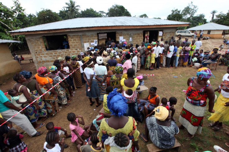 People wait to vote during a presidential election at a polling station in Feefee, Bomi county
