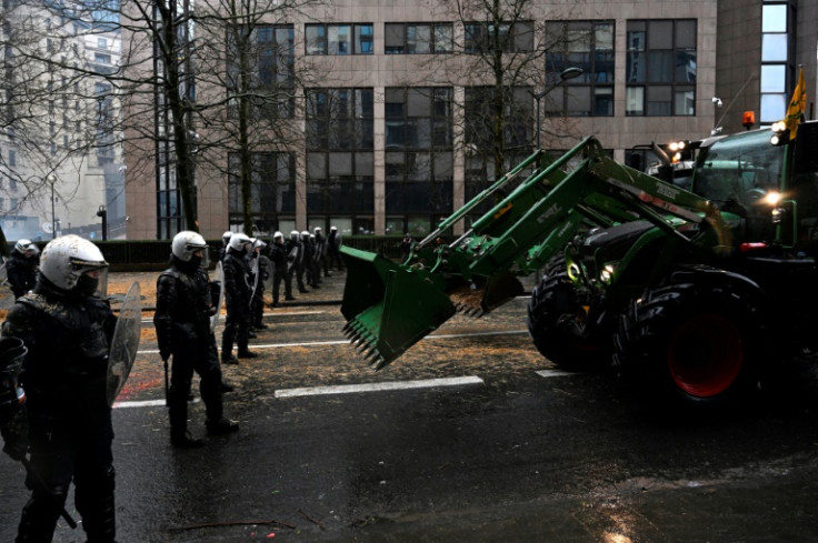 A farmer uses a tractor to force a police barrage in Brussels on February 26, 2024