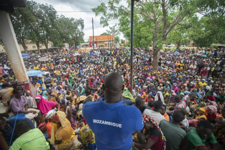 A staff member of the World Food Program addresses thousnds of displaced people from Cabo Delgado province in the town of Namapa