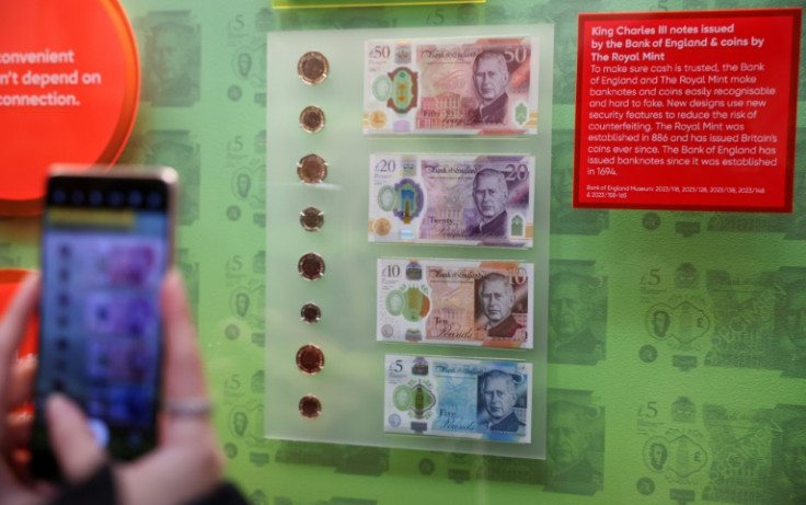 Members of the media photograph banknotes and coins that feature an image of Britain's King Charles III, during a photocall for 'The Future of Money' exhibition, at the Bank of England Museum in London on February 27, 2024
