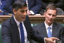 Finance minister Jeremy Hunt (R) has dampened hopes of tax cuts as Prime Minister Rishi Sunak's (L) Conservatives trail in opinion polls