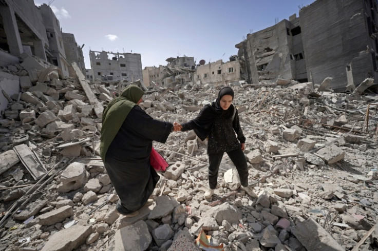 Palestinians walk in the rubble of buildings destroyed in Israel's bombardment of Khan Yunis