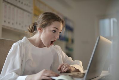 Shocked woman looking at laptop