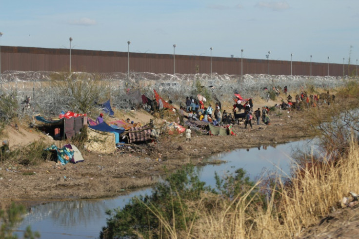 Migrants on the Mexican side of the border wait to cross into the United States at a point near El Paso, Texas, on March 19, 2024