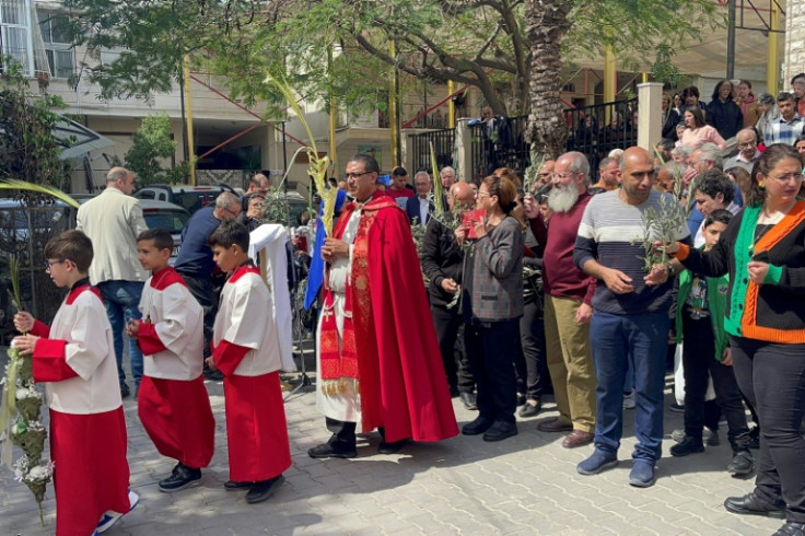 Palestinian Christians gather outside the only Roman Catholic church in Gaza City to mark Palm Sunday