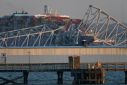 The steel frame of the Francis Scott Key Bridge sits on top of a container ship after it struck the bridge in Baltimore, Maryland, on March 26, 2024