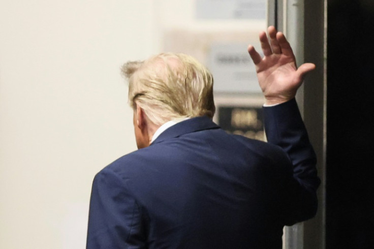 Trump gestures to reporters during a break in his New York trial