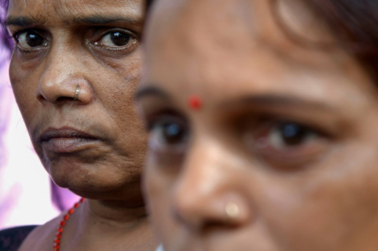 Relatives wait outside a hospital mortuary to collect bodies of family members killed in a fire at an amusement park in India's Gujarat