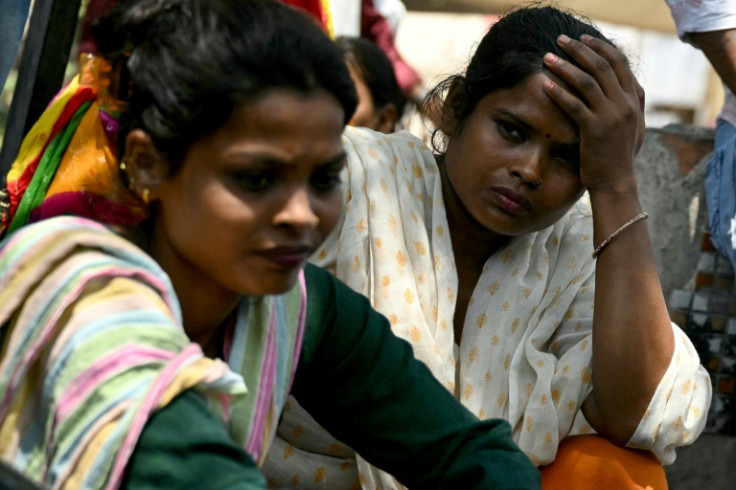 Mothers wait to identify the bodies of their children a day after a fire broke out at a children's hospital in New Delhi