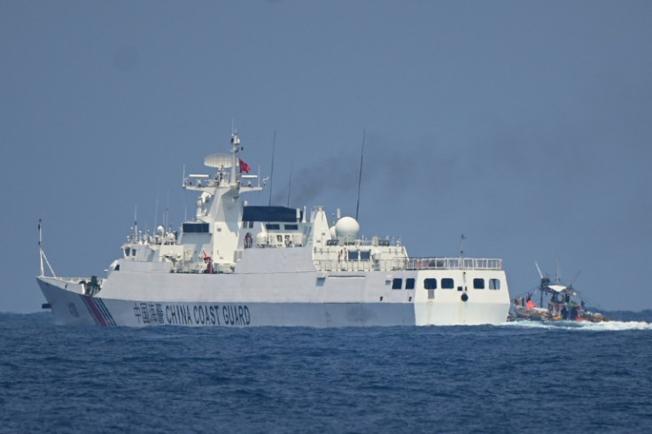 A China Coast Guard ship maneuvers past a Philippine fishing boat in the disputed South China Sea