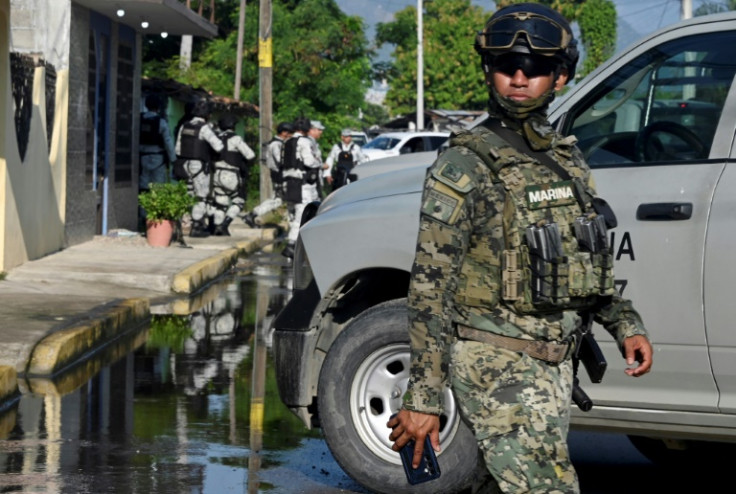 Mexican security personnel at the scene of an armed attack that left five people dead in a suburb of Acapulco