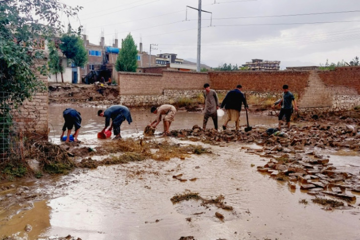 Afghans drain flood waters with shovel and buckets, after heavy rains on the outskirts of Kabul on August 20, 2024 -- the country is deemed the sixth most vulnerable to climate change